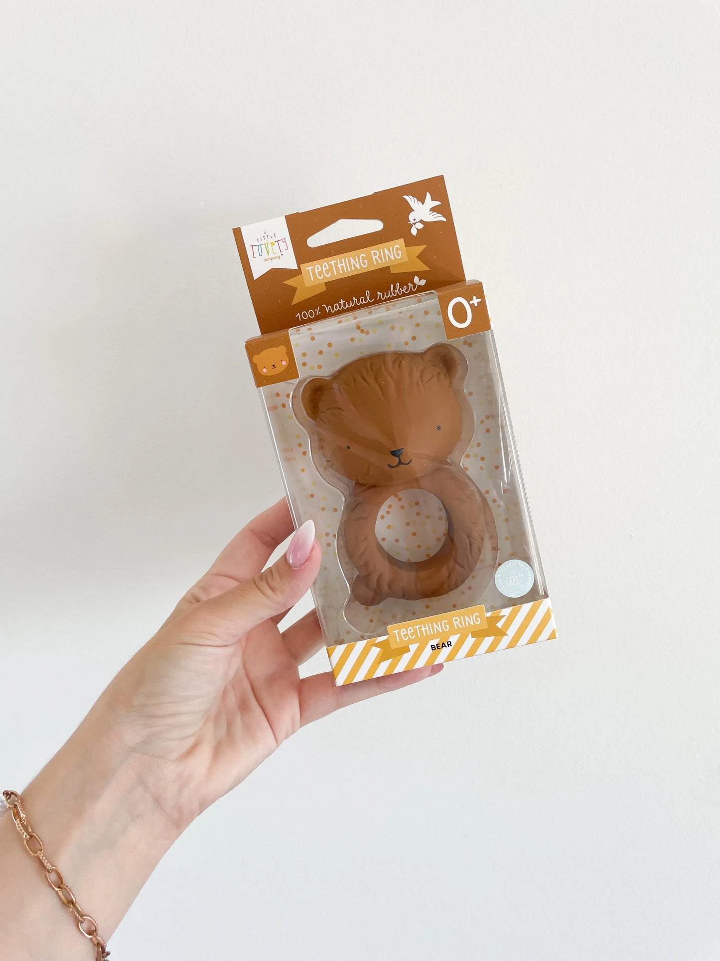 Packaging du hochet ours tenu à la main sur fond blanc – présentation boîte cadeau