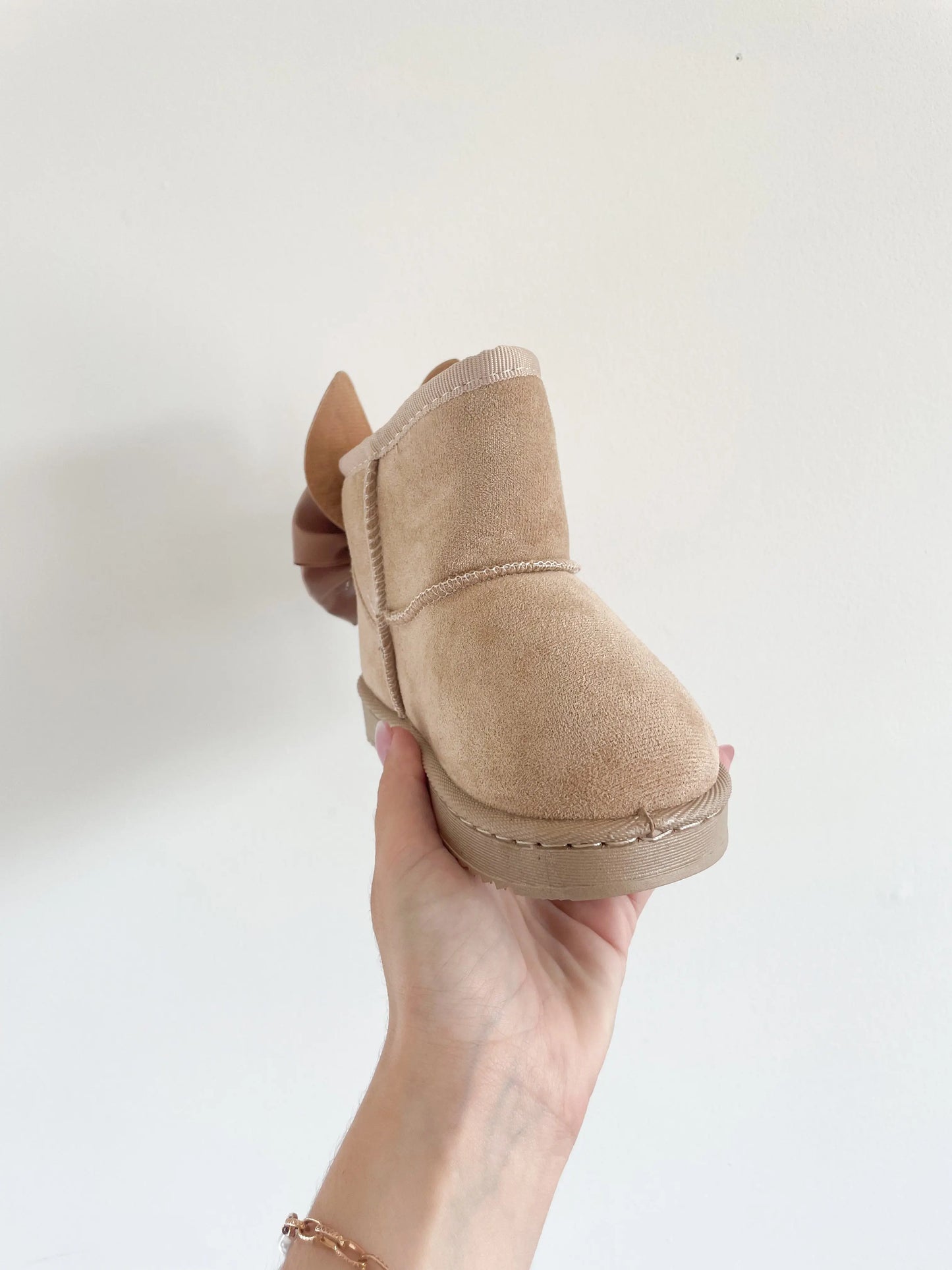 Bottines fourrées beige pour bébé fille, avec nœud et oreilles de lapin, présentées de face