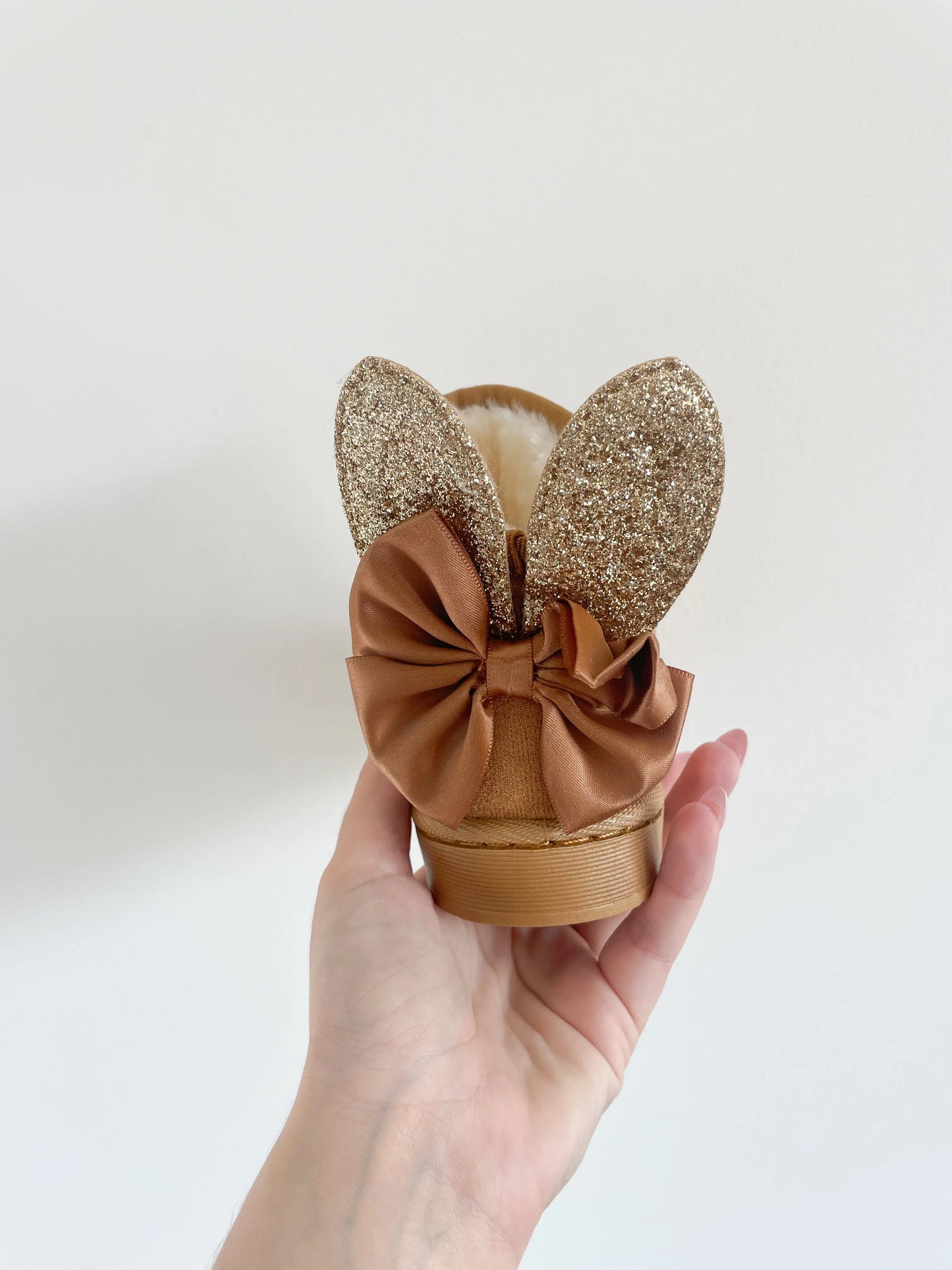 Bottines fourrées camel pour bébé, vues de derrière, soulignant les détails des oreilles et du nœud décoratif