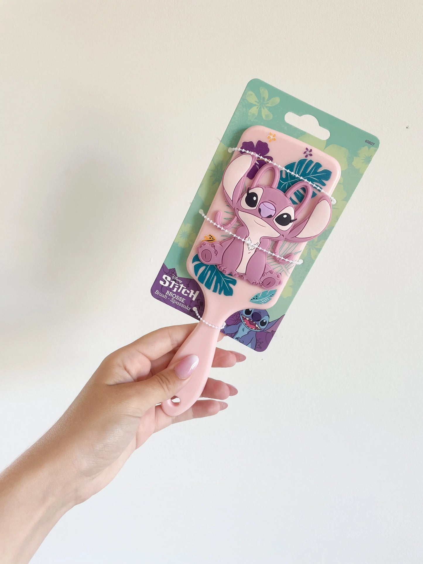 Brosse à cheveux Angel pour enfant rose en silicone 3D . Brosse stitch angel pris dans la main sur fond blanc