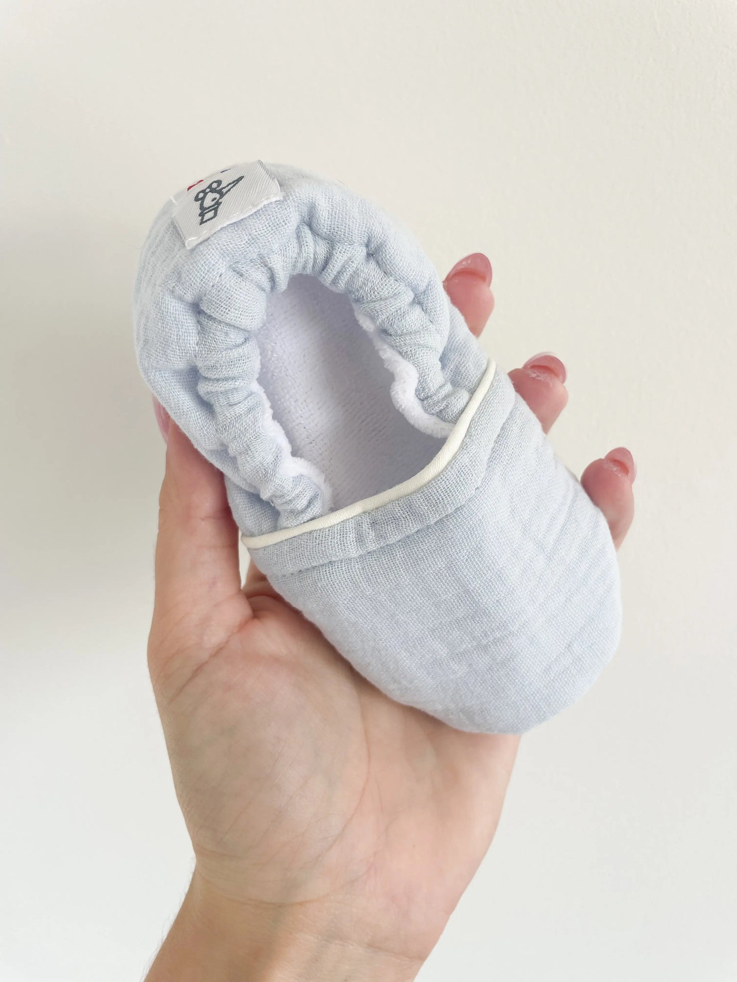 Démonstration de la souplesse des chaussons bébé Artic, matière douce et confortable