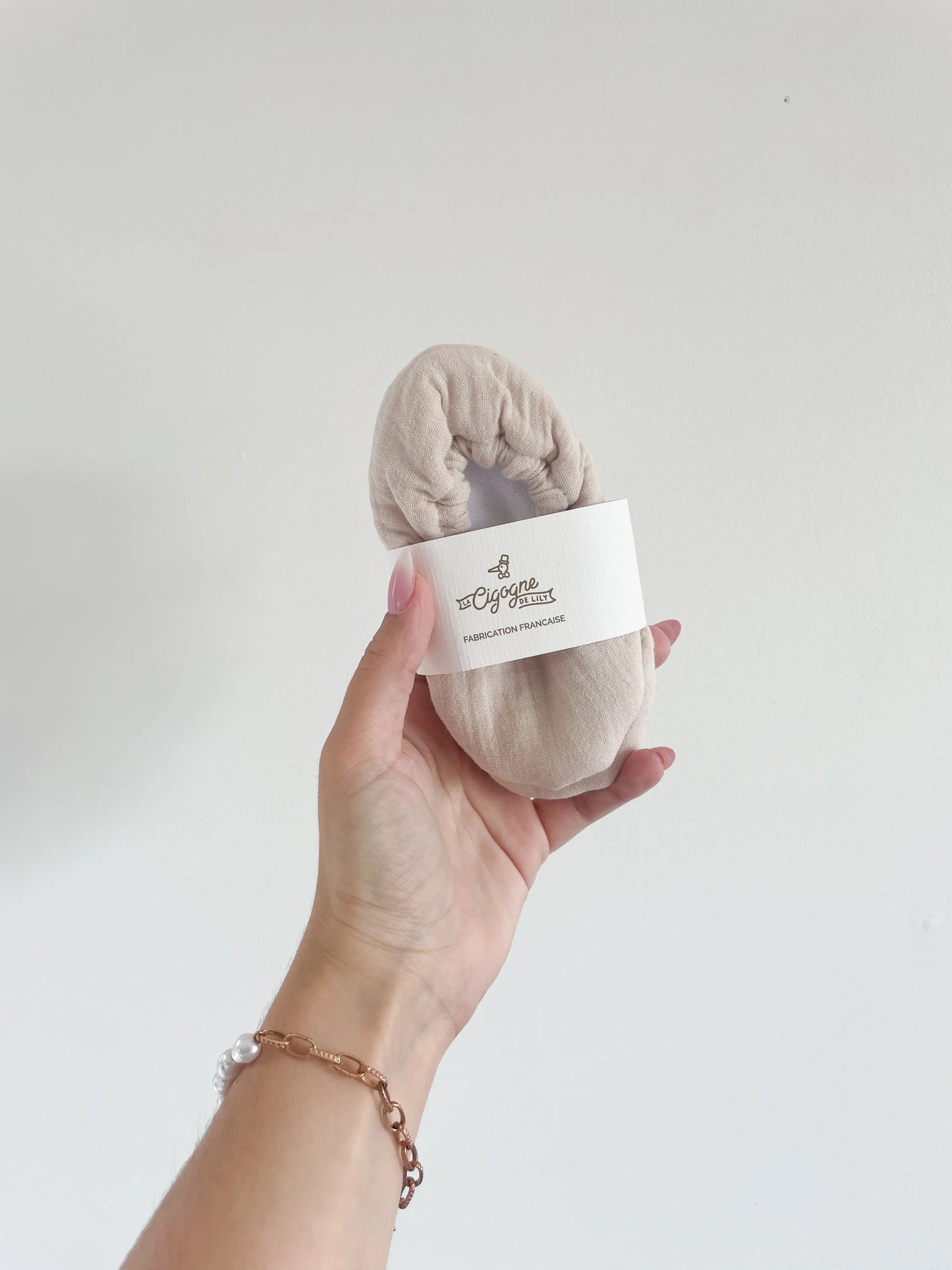 Chaussons en cuir souple sable pour bébé, vue du dessus avec le packaging