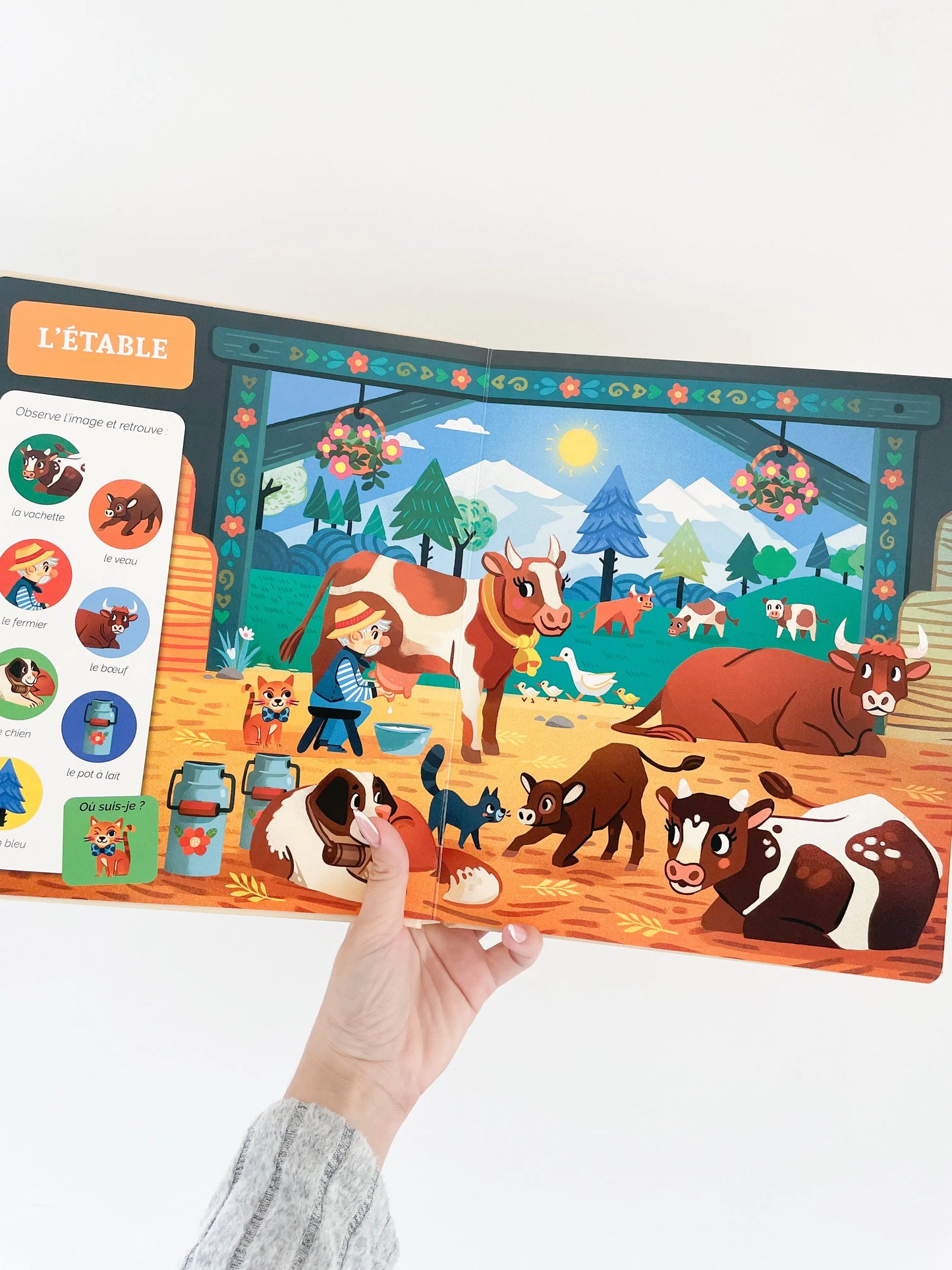 Cherche et trouve des tout petits sur le theme de la ferme. Page intérieur du livre sur l'étable avec les vaches. Livre pour bébé
