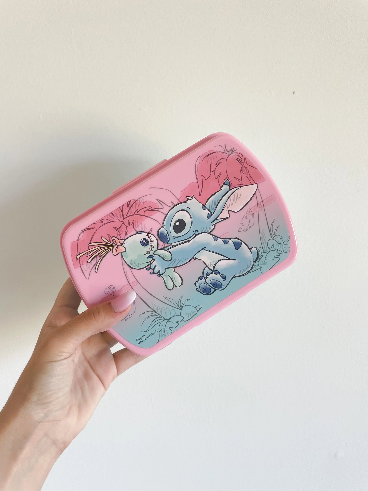 Boite à gouter stitch rose fille. Prêt a offrir. Stitch avec un doudou sur la boite à gouter. Pris dans une main sur fond blanc