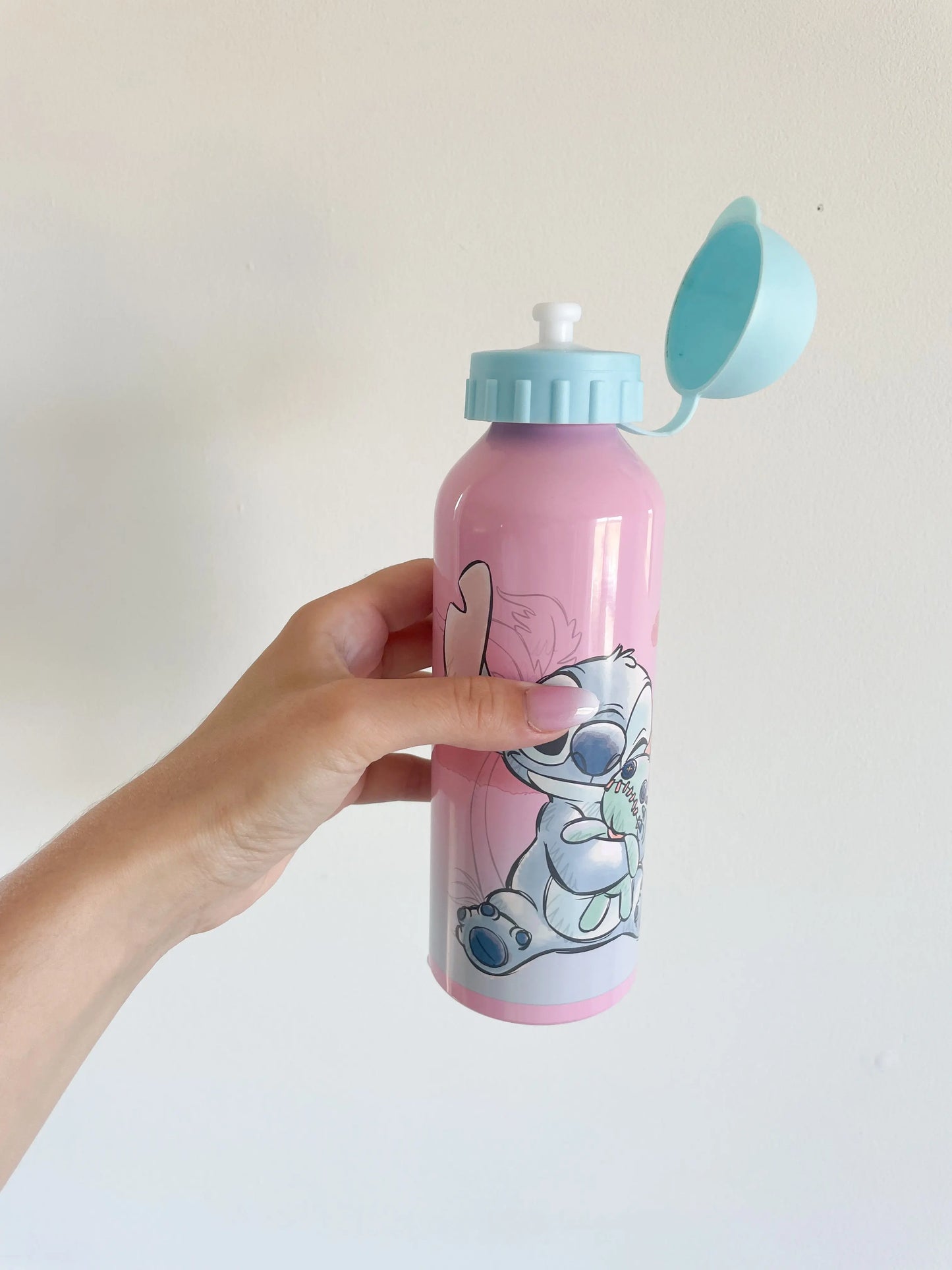 Main tenant la gourde Stitch pour enfant ouverte, embout pour boire apparent