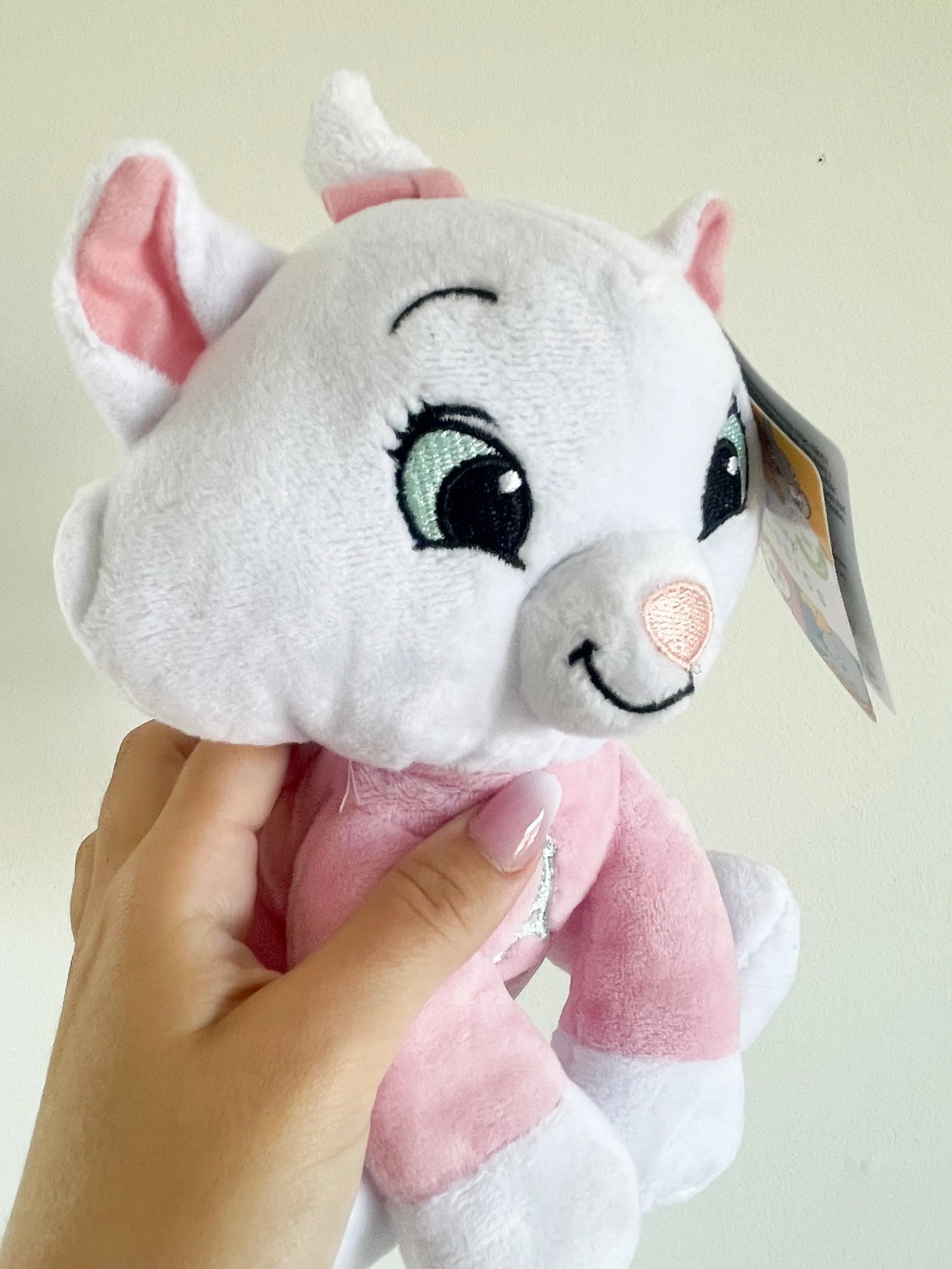 Zoom sur la peluche Marie des aristochats – peluche avec oreilles roses et nœud rose
