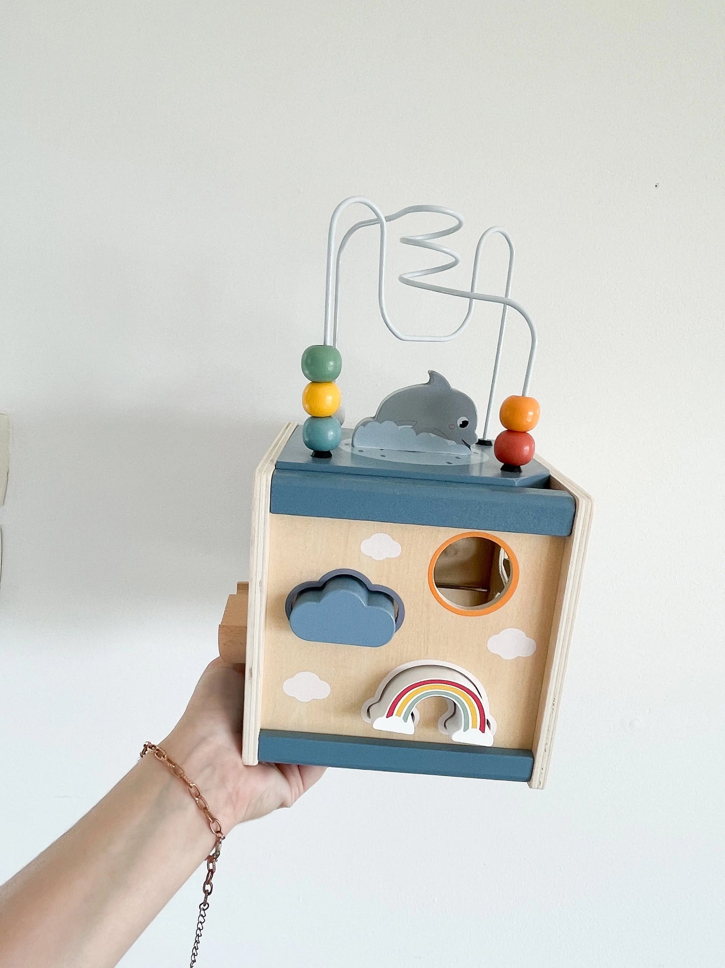 Cube d’activité tenu à la main sur fond blanc– jeu d'encastrement