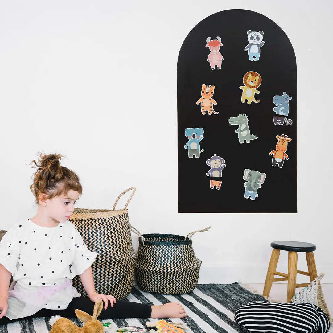 Enfant jouant avec les magnets animaux sur un tableau noir en forme d'arche