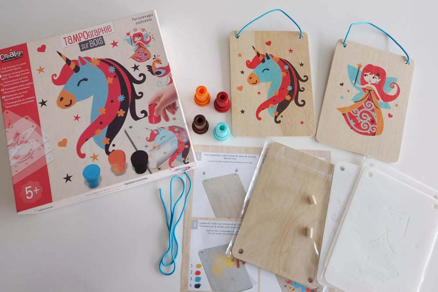 Vue du contenu du coffret : planchettes en bois, pochoirs et accessoires de peinture