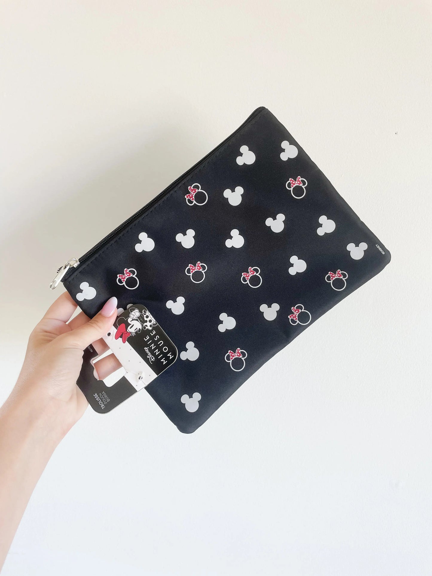Trousse de toilette Minnie et mickey disney. Trousse plate mickey. Trousse prise dans une main sur fond blanc