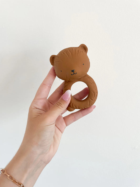 Anneau de dentition en forme d’ours tenu à la main sur fond blanc
