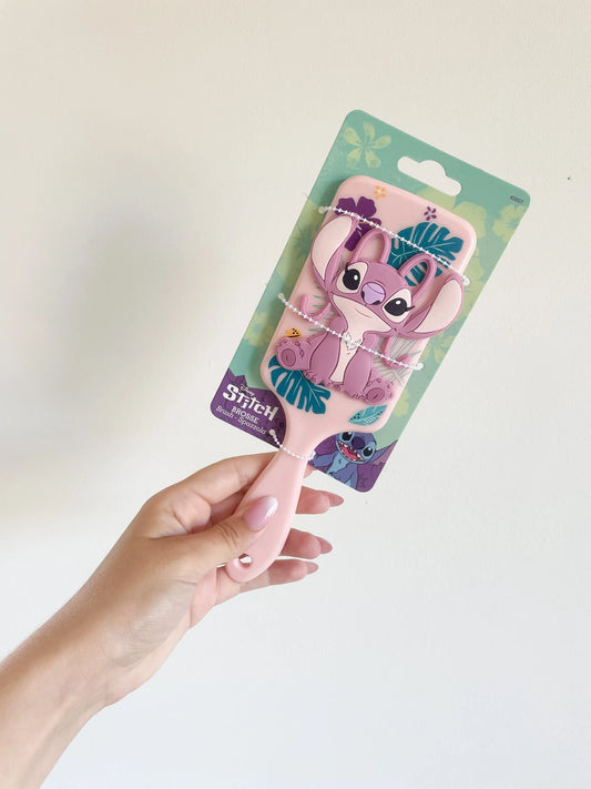 Brosse à cheveux Angel pour enfant rose en silicone 3D . Brosse stitch angel pris dans la main sur fond blanc