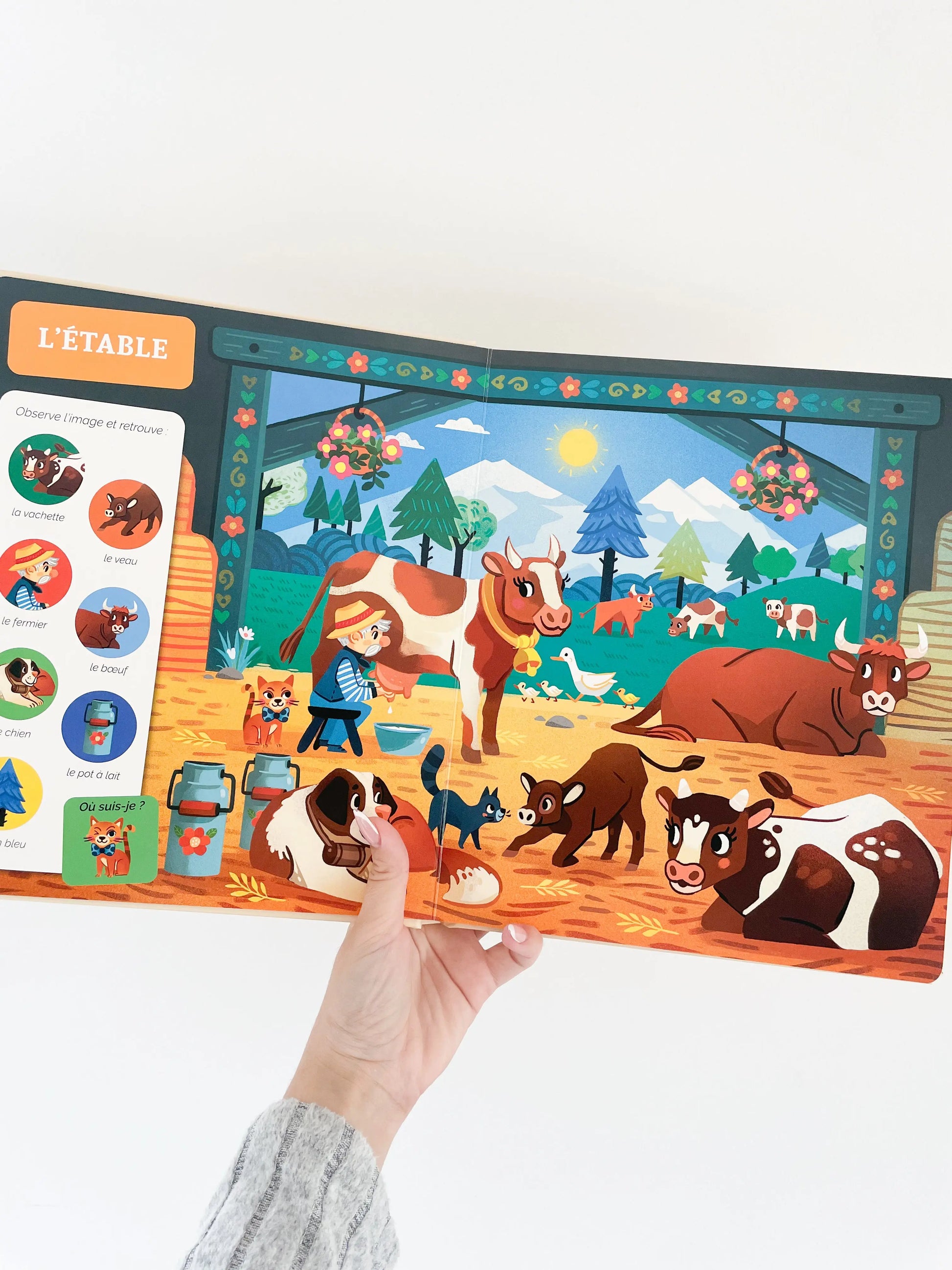 Cherche et trouve des tout petits sur le theme de la ferme. Page intérieur du livre sur l'étable avec les vaches. Livre pour bébé 