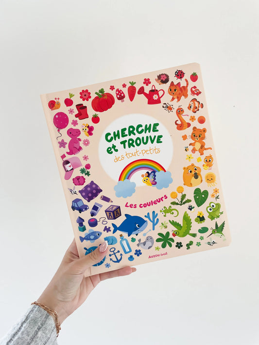 Cherche et trouve des tout petits - Les couleurs. Page de couverture très coloré. Adapté aux bébés de 1 an. Livre tenu a la main sur un fond blanc