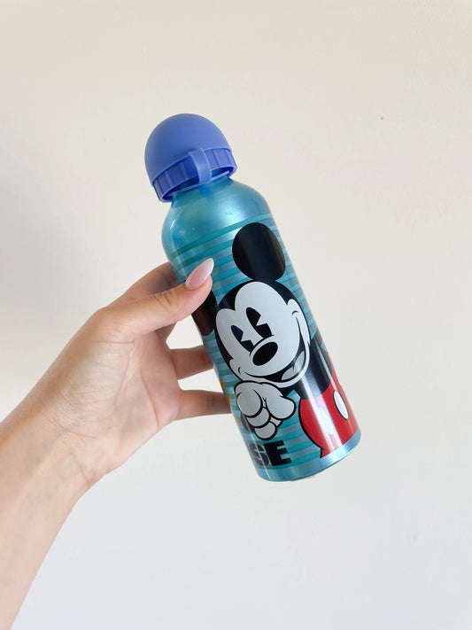 Gourde Mickey disney pour enfant bleu. Avec la tete de mickey dessus. Goutrde dans une main sur fond blanc