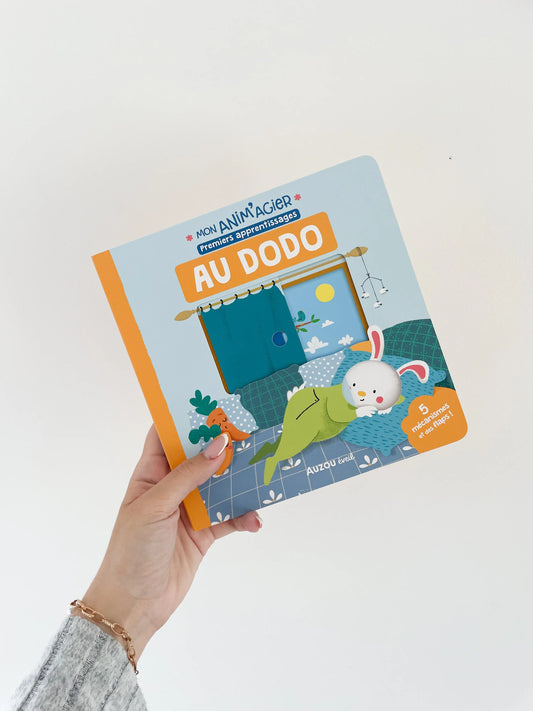 Livre MON ANIM'AGIER - Au dodo avec mécanisme. Livre avec mécanisme pour enfant dès 18mois. Page de couverture. Livre dans une main sur fond blanc