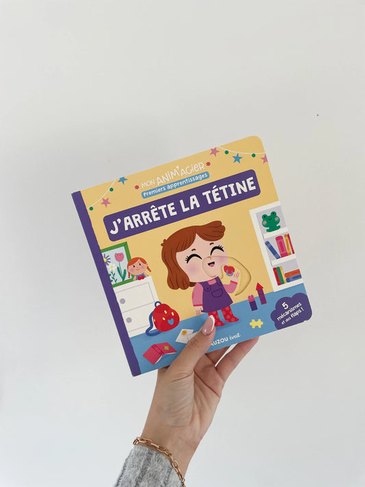 Livre MON ANIM'AGIER - J'arrête la tétine enfant 18 mois. Livre pour arrêter la tétine avec un livre à mécanisme. Page de couverture. Livre dans une main sur fond blanc 