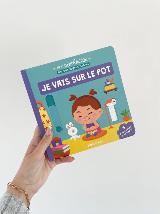 MON ANIM'AGIER - Je vais sur le pot. Livre à mécanisme. Dès 18mois. Page de couverture je vais sur le pot. Livre dans une main sur fond blanc