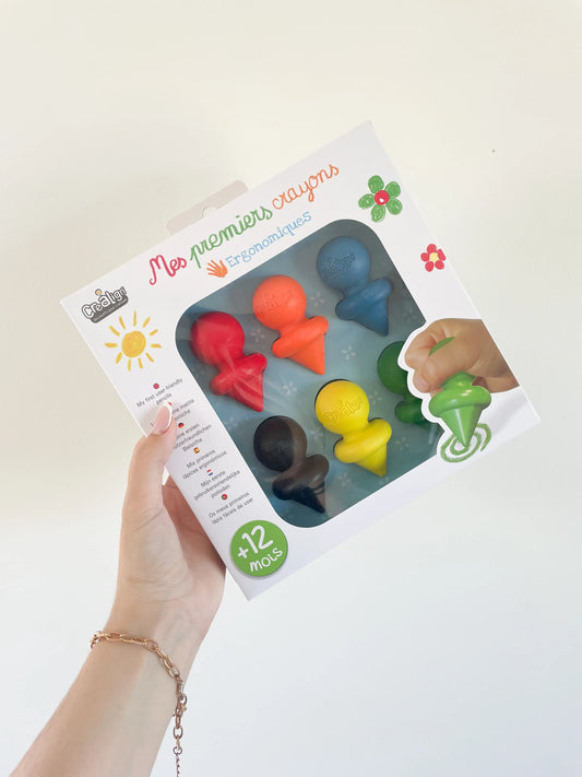 Boîte Mes premiers crayons pour bébé dès 12 mois, ergonomiques et colorés, tenue a la main sur fond blanc
