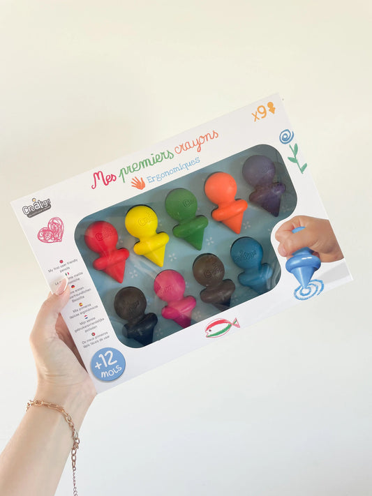Boîte Mes premiers crayons ergonomiques pour bébé, lot de 9 couleurs vives, dès 12 mois. Photo prise dans la main sur fond blanc
