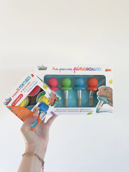 Coffret Mes premiers pinceaux et peintures Créalign pour bébé dès 12 mois, présenté de face dans la main sur fond blanc

