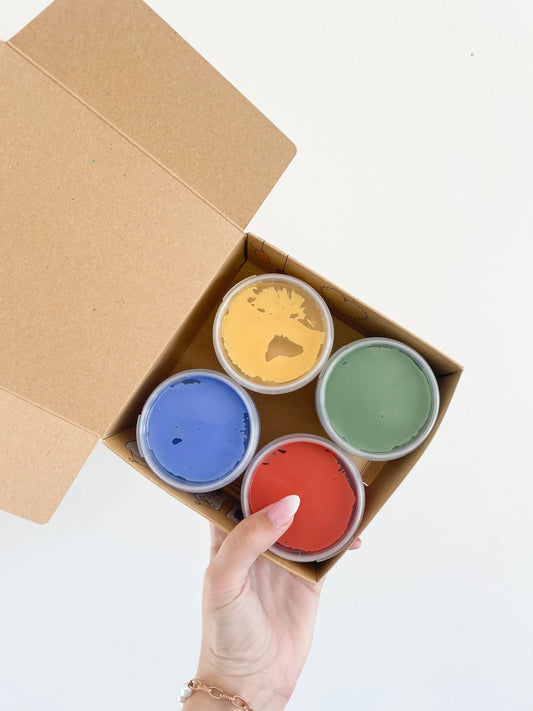 Coffret peinture au doigt bio vegan Aki – 4 pots colorés dans boîte kraft. Pris dans la main sur fond blanc.