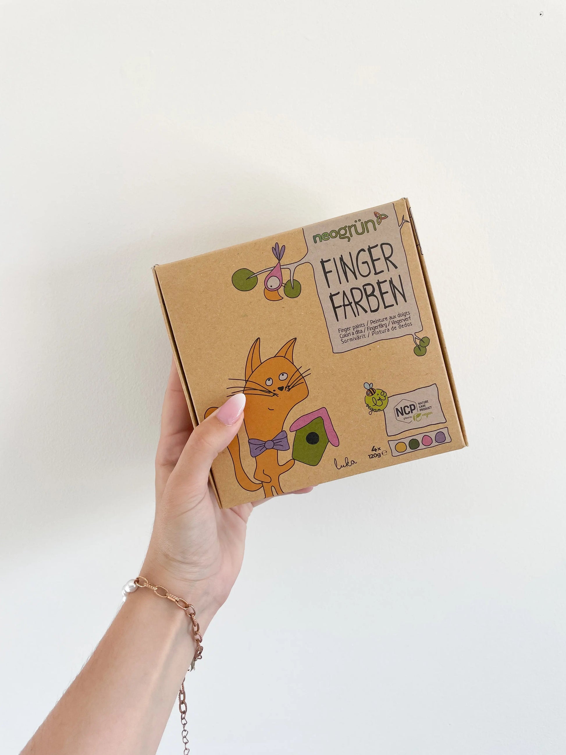 Coffret peinture packaging kraft vegan Luka tenu à la main sur fond blanc – Activité créative enfant dès 2 ans