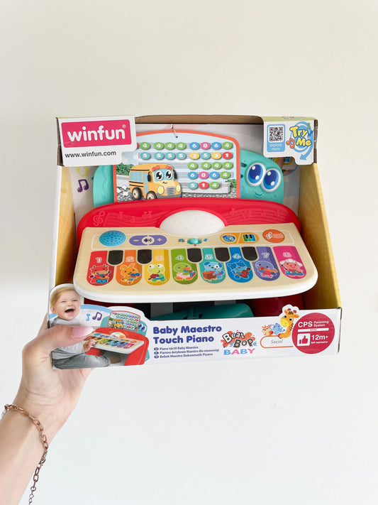 Piano pour bébé tactile dès 12mois. Piano electronique. Tenue dans une main sur fond blanc