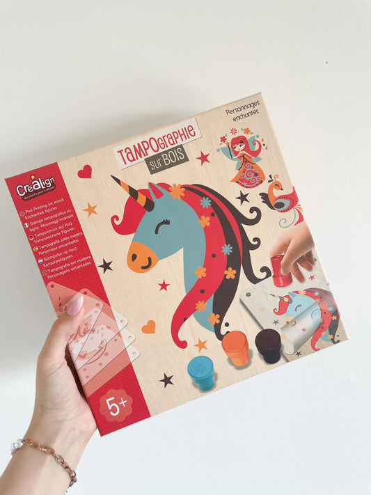 Coffret de tampographie sur bois "Personnages enchantés" tenu en main sur fond blanc