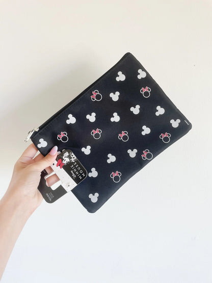 Trousse de toilette Minnie et mickey disney. Trousse plate mickey. Trousse prise dans une main sur fond blanc 